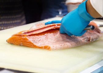 chef slicing raw fresh salmon, Chef preparing a fresh salmon on a cutting board