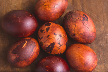 Obraz premium Easter eggs on wooden background. Painted brown with spots and cracks. Selective focus macro shot with shallow DOF
