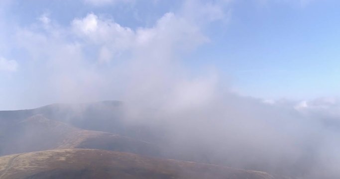 Aerial view: Flying in the fog over amazing mountains. 4k