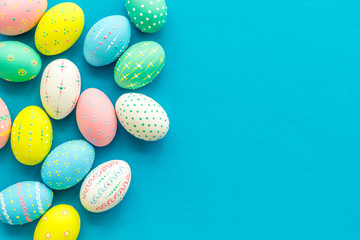 Easter composition. Decorated pastel Easter eggs on blue background top view copy space