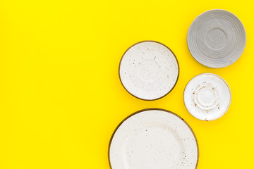 Ceramic plates pattern on yellow background top view space for text