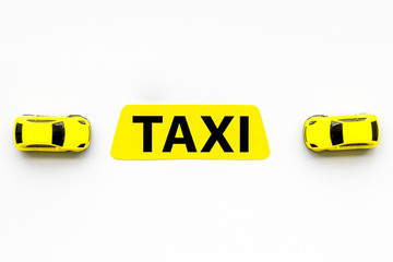 Taxi concept. Yellow service sign text taxi near car toy on white background top view space for text