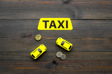 Taxi operator concept. Chip service. Price of services. Sign taxi ner car toy and coins on dark...