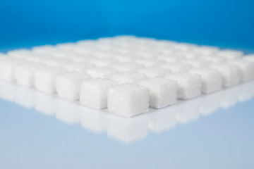 Table top shot Group of Sugar cubes vary position on light blue background