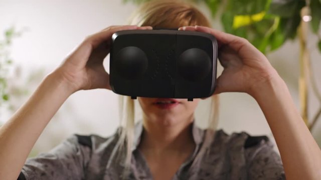 young woman adjusting virtual reality goggles and putting them on
