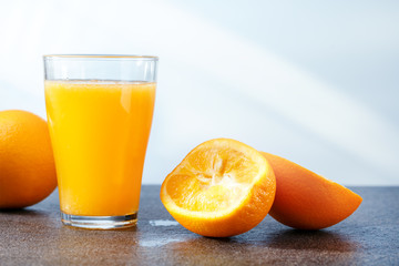 Fresh orange juice and fresh oranges on the table with copy space.