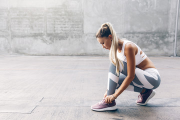 Fitness sport woman in fashion sportswear doing workout over gray wall - obrazy, fototapety, plakaty