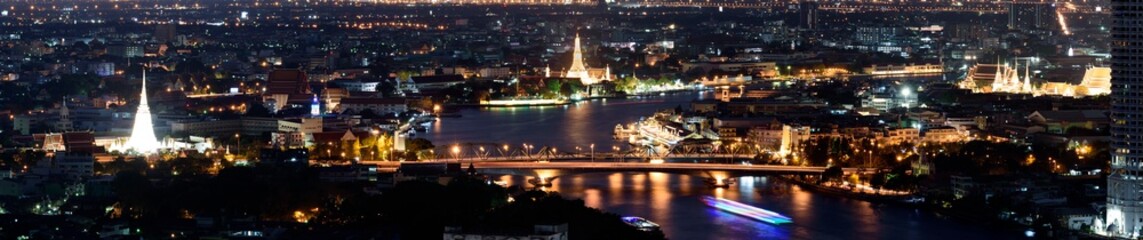 Beautiful panoramic image of cityscape of Bangkok in the evening viewing The Grand Palace , Wat Arun Ratchawararam Ratchawaramahawihan and Chao Phraya river , Thailand