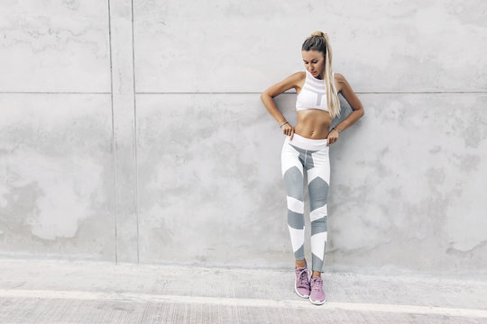 Fitness sport model in fashion sportswear posing over gray wall © Alena Ozerova