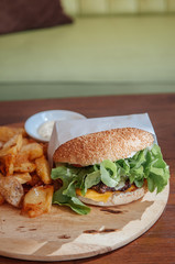 Beef hamburger, fried potato chunks close up shot