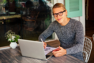 A smiling man with laptop outdoor summer time vacation