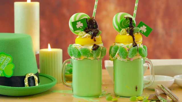 Happy St Patrick's Day on-trend holiday freak shakes milkshakes decorated with candy and lollipops.