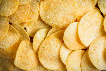 Salty chips on the rustic background. Selective focus. Shallow depth of field.