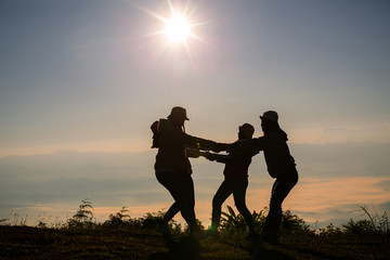 Silhouettes of peoples take photos on top of mountain with sunrise