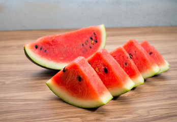 Fresh sliced watermelon on brown wooden table background