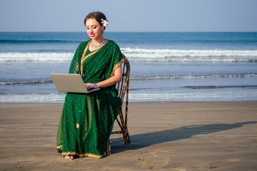 remote working concept dream job.beautiful and young indian woman in green stylish sari ,curly...