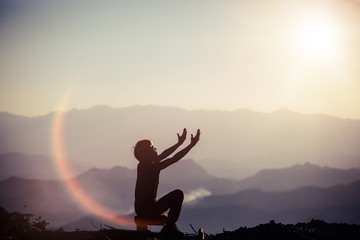 Silhouette illustration of a man praying outside at beautiful landscape