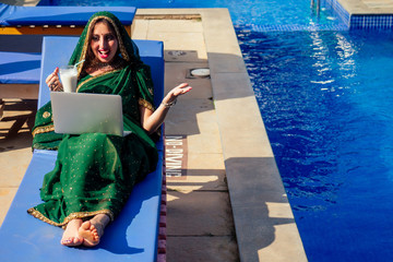 remote working concept dream job.beautiful and young indian woman in green stylish sari...