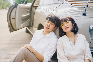 Romantic scene of young couple sitting outdoor and closed eyes together. Sweet love.