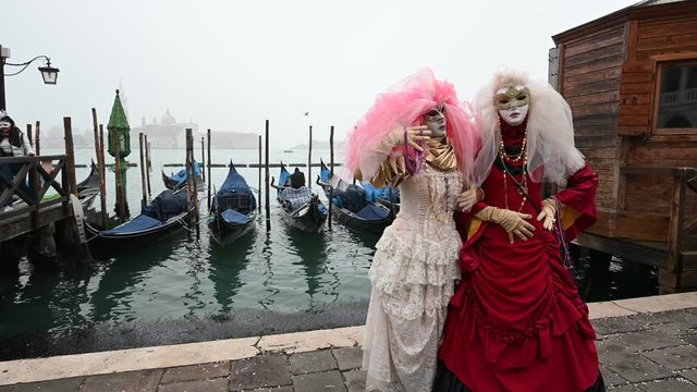   Venice - carnival masks are photographed with tourists in Piazza San Marco