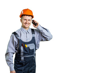 Architect or builder engineer smiling at you, construction worker in orange helmet talking on a mobile phone. Isolated.