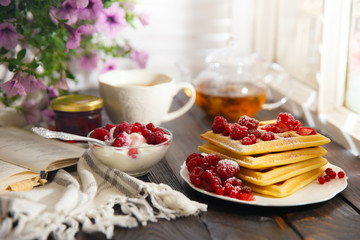 Plate with tasty waffles on wooden table
