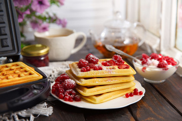 Plate with tasty waffles on wooden table
