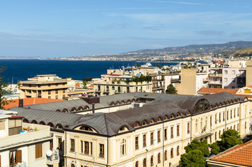 Fototapeta na wymiar Aerial view of houses, streets and the Strait of Messina between Reggio Calabria and Sicily from the Aragonese Castle in Reggio Calabria, Italy