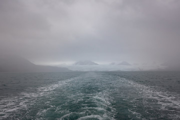 Svalbard glacier (Nordenskioldbreen) in the fog seen from the boat, Spitsbergen, Norway