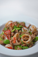 Stir-Fried Twisted Cluster Bean with squid/Bitter Bean on a White Dish