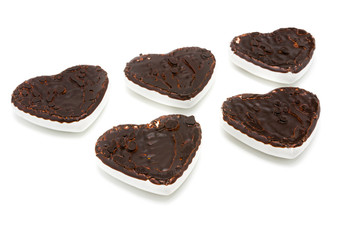 Gingerbread cookies in the form of hearts covered with white glaze and dark chocolate on an isolated background  