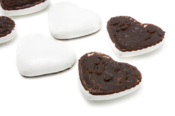 Gingerbread cookies in the form of hearts covered with white glaze and dark chocolate on an isolated background  