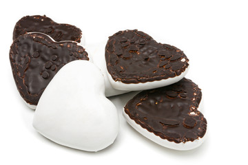 Gingerbread cookies in the form of hearts covered with white glaze and dark chocolate on an isolated background  