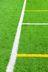 Obraz premium Football field green background with white and yellow line. Sport texture.