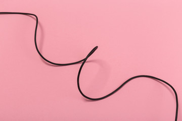 black wire isolated on a pink background abstraction