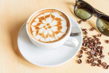 hot cappuccino with nice milk pattern with coffee bean on table