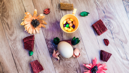Easter, preparation for Easter, still life, story for Easter, eggs, colored objects, flowers, wooden background, wreath,