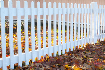 Beautiful colorful autumn scene with white fence and fall colors in Finland.