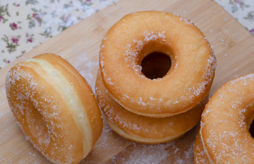 Sugar donuts on wooden board