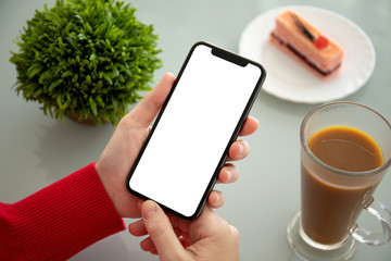 female hands holding phone with isolated screen in a cafe