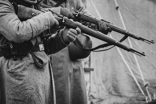 Two German soldiers of the Second World War with rifles in their hands ready to fire. Black and white photo