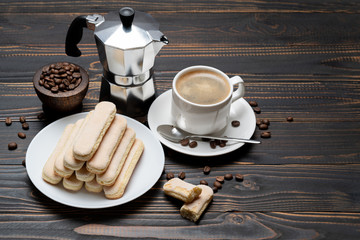 Italian Savoiardi ladyfingers Biscuits and cup of coffee on wooden backgound