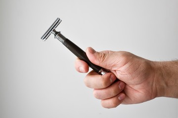 Man's hand in hand shaving machine. Shaving items. To shave a man. Shaving. Beard.