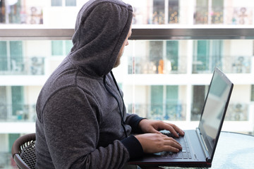 Cybercrime, hacking and technology concept - male hacker writing code or using computer virus...