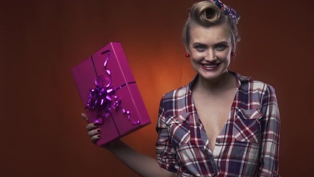 Pin up girl with amazing hairstyle is happy with her present, slow motion