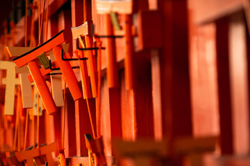 Closeup of red Wooden Torii or Japanese gates model. A amulets for luck at Fushimi Inari shrine in Kyoto, Japan
