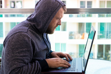 Cybercrime, hacking and technology concept - male hacker writing code or using computer virus...