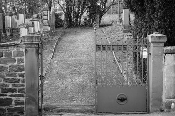 Entrance to vandalised graves in with nazi symbols in blue spray-painted on the damaged graves - Jewish cemetery in Quatzenheim near Strasbourg 