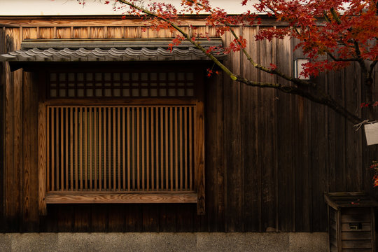 Japan old house, wooden wall and window behide the Meple tree and red leaf