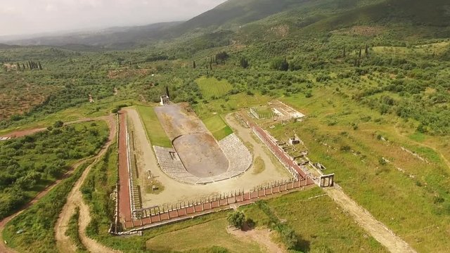 Aerial drone video of unique and well preserved archaeological site and citadel of Ancient Messene featuring massive stadium and theatre, Messinia, Peloponnese, Greece